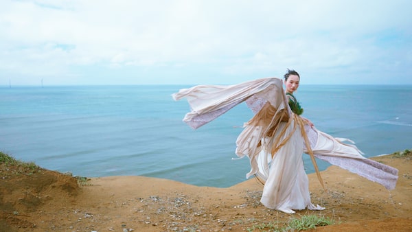 Imagen de ejemplo que muestra a una mujer con traje de época y la costa de fondo